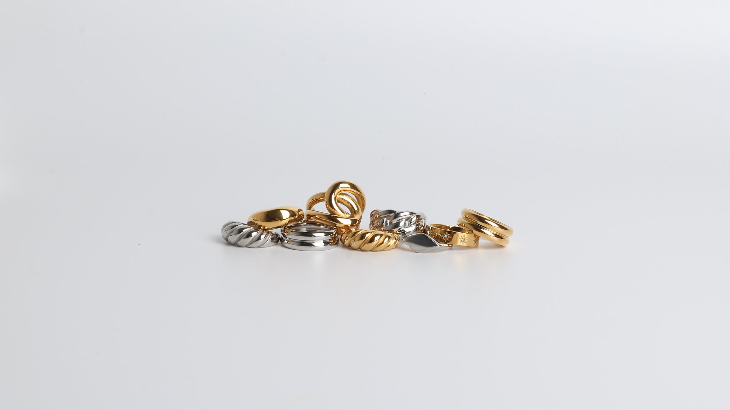 Stack of MARRIN COSTELLO JEWELRY rings, mix metals, showcasing all the different styles of MC rings, from dainty to statement rings. Available in 14k gold plated stainless steel, and polished stainless steel.