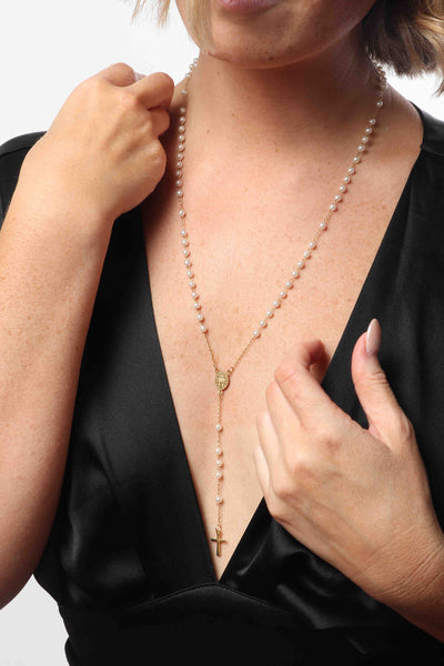 Marrin Costello wearing Marrin Costello Jewelry Estelle Rosary with pearls as functional prayer beads with lobster clasp closure and lariat drop. Waterproof, sustainable, hypoallergenic. 14k gold plated stainless steel.