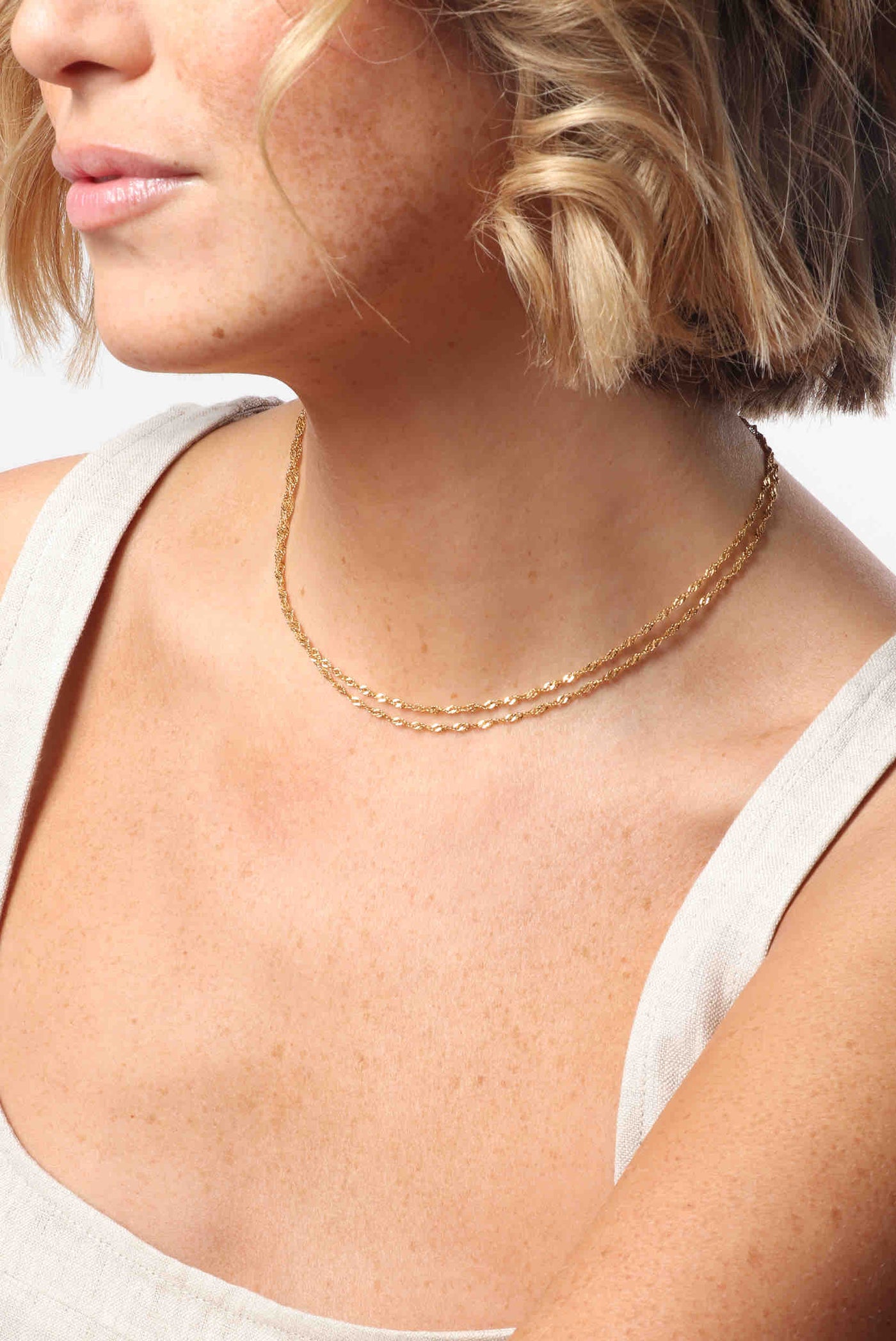 Marrin Costello wearing Marrin Costello Jewelry Helix Layers with thin dainty helix chains layered in a two in one necklace with lobster clasp closure and extender. Waterproof, sustainable, hypoallergenic. 14k gold plated stainless steel.