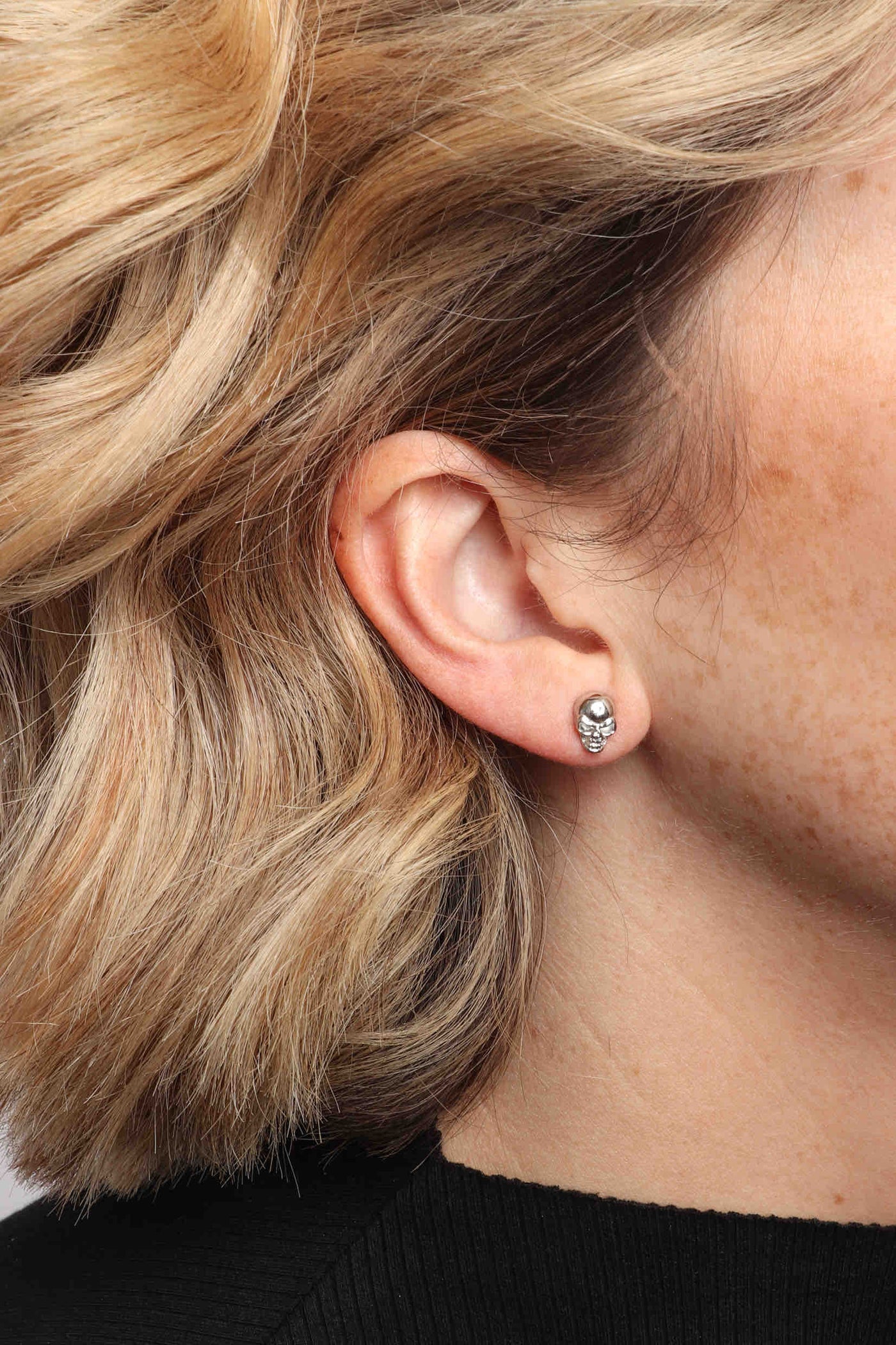 Marrin Costello wearing Marrin Costello Jewelry Hyde Studs skull post back earrings — for pierced ears. Waterproof, sustainable, hypoallergenic. Polished stainless steel.