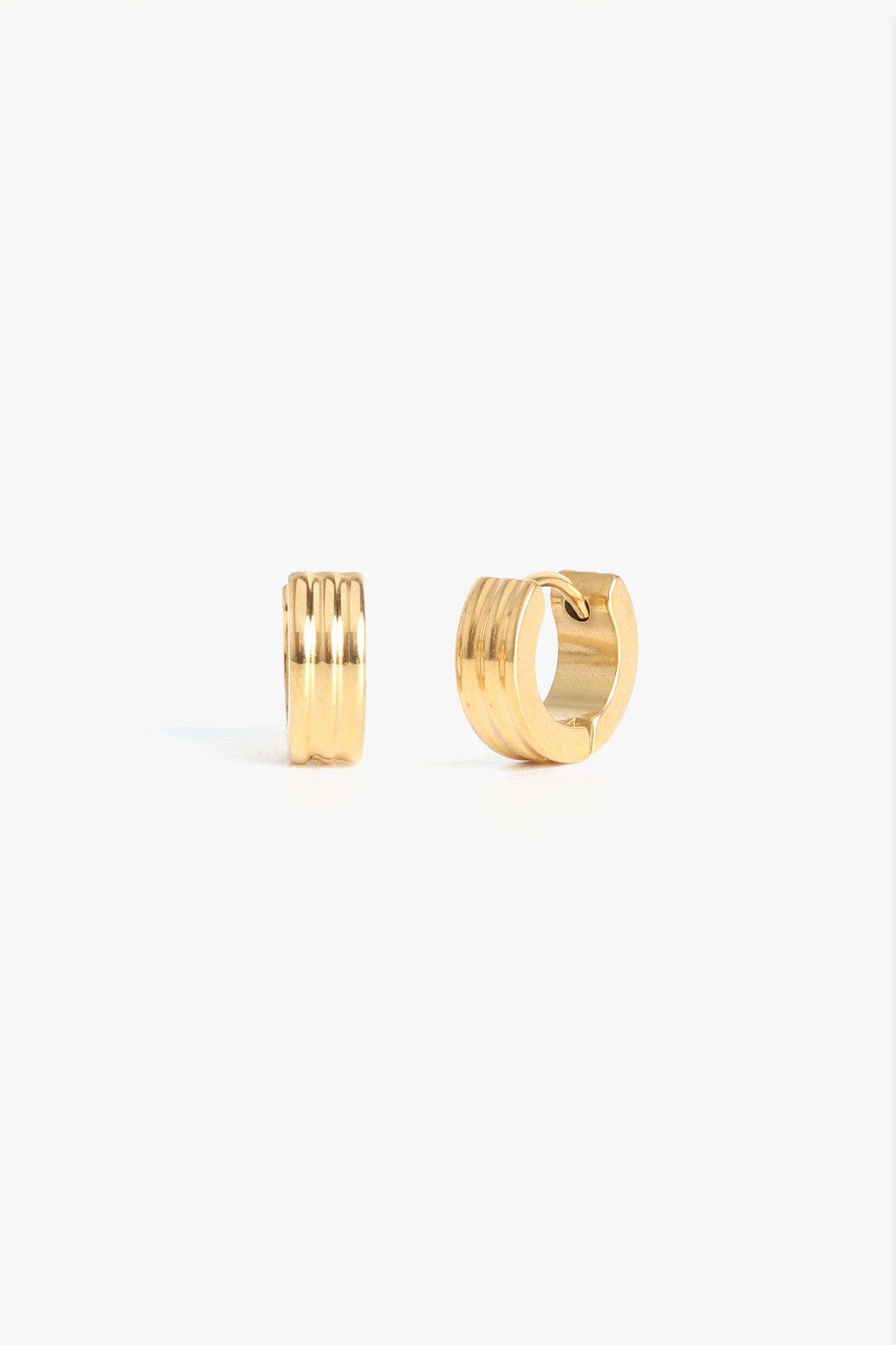 Marrin Costello Jewelry Evelyn 3mm Huggies ribbed small hoops with click tension hinge closure— for pierced ears. Waterproof, sustainable, hypoallergenic. 14k gold plated stainless steel.