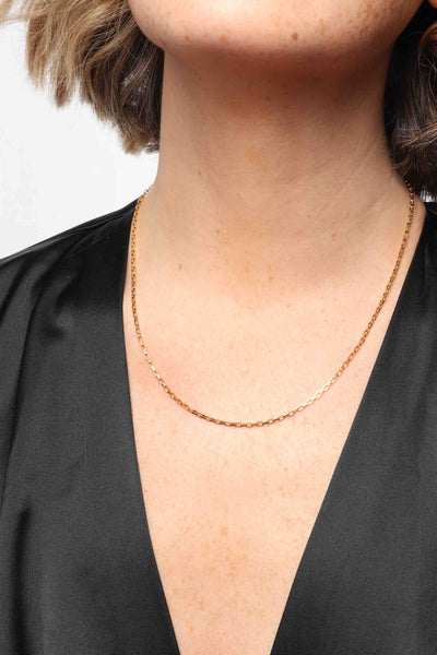 Marrin Costello wearing Marrin Costello Jewelry Mirage Chain delicate dainty rectangle link chain with lobster clasp closure and extender. Waterproof, sustainable, hypoallergenic. 14k gold plated stainless steel.