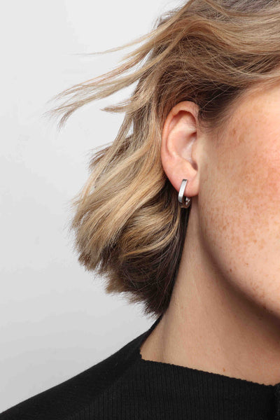 Marrin Costello wearing Marrin Costello Jewelry Ophelia Huggies u shaped horseshoe small hoops click tension hinge — for pierced ears. Waterproof, sustainable, hypoallergenic. Polished stainless steel.