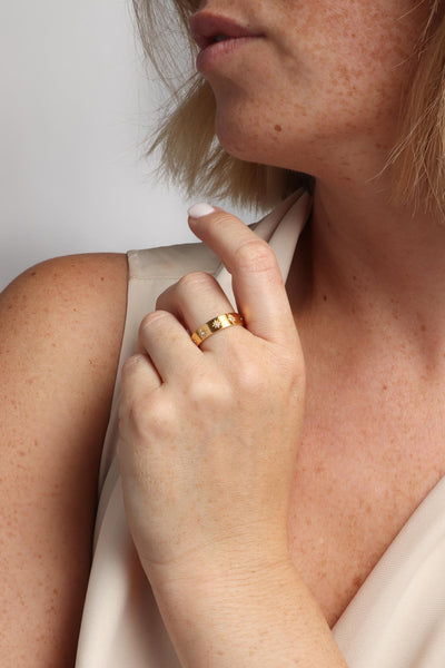 Marrin Costello wearing Marrin Costello Jewelry Orion Band star motif ring with CZ detail. Available in sizes 6, 7, 8. Waterproof, sustainable, hypoallergenic. 14k gold plated stainless steel.