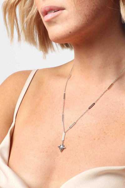 Marrin Costello wearing Marrin Costello Jewelry Orion Lariat drop neckalce with star pendant, lobster clasp closure and extender. Waterproof, sustainable, hypoallergenic. Polished stainless steel.