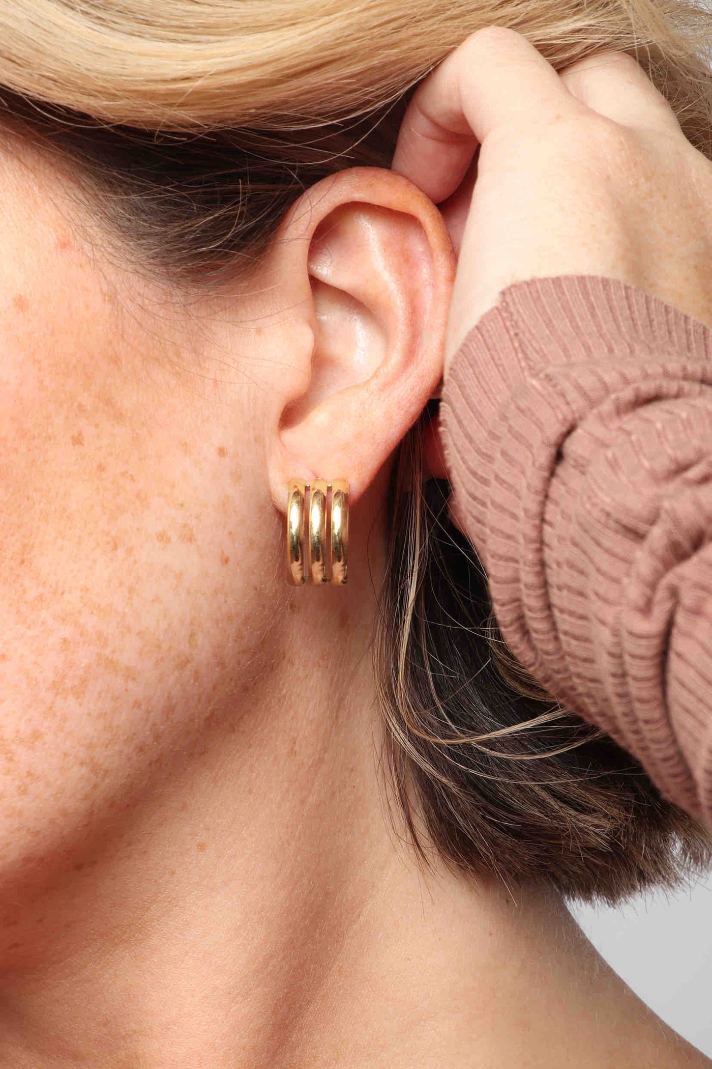 Marrin Costello wearing Marrin Costello Jewelry Petra Hoops triple ribbed post back earrings — for pierced ears. Waterproof, sustainable, hypoallergenic. 14k gold plated stainless steel.