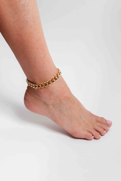 Marrin Costello wearing Marrin Costello Jewelry Queens Cuban Link chain anklet with lobster clasp closure and extender. Waterproof, sustainable, hypoallergenic.14k gold plated stainless steel.