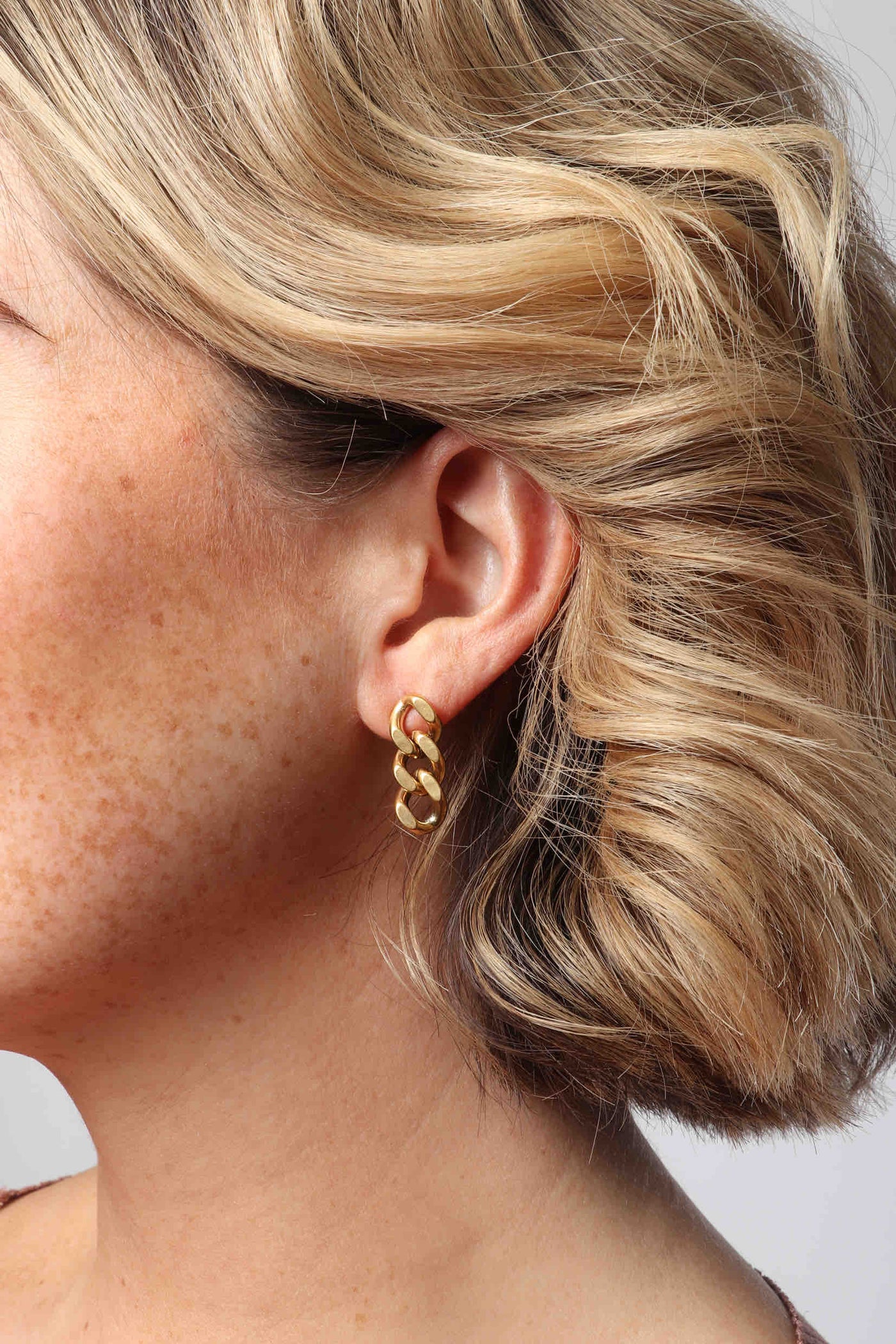 Marrin Costello wearing Marrin Costello Jewelry Queens Drops cuban link post back earrings — for pierced ears. Waterproof, sustainable, hypoallergenic. 14k gold plated stainless steel.