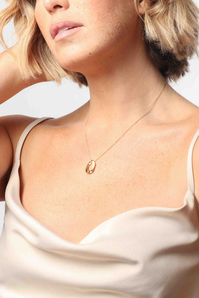 Marrin Costello wearing Marrin Costello Jewelry Queens Pendant necklace with single cuban link chain link with lobster clasp closure and extender. Waterproof, sustainable, hypoallergenic. 14k gold plated stainless steel.