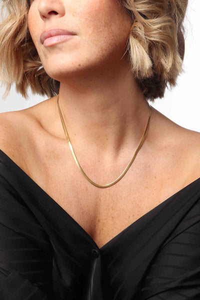 Marrin Costello wearing Marrin Costello Jewelry Ramsey Chain 3mm snake herringbone chain with lobster clasp closure and extender. Waterproof, sustainable, hypoallergenic. 14k gold plated stainless steel.